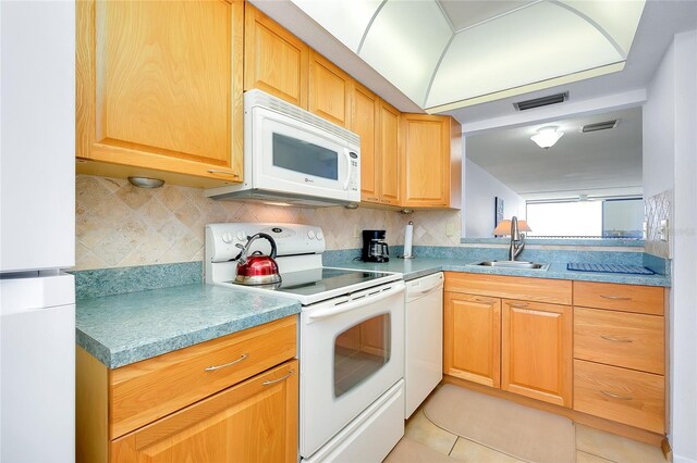 kitchen with backsplash, white appliances, sink, and light tile floors