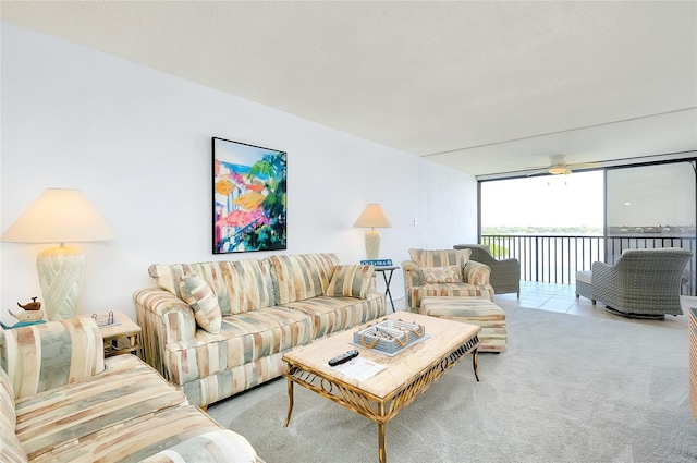 carpeted living room with floor to ceiling windows and ceiling fan