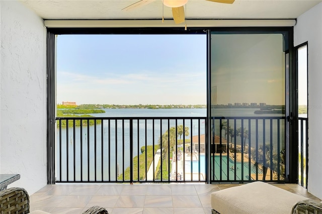 sunroom featuring a water view and ceiling fan