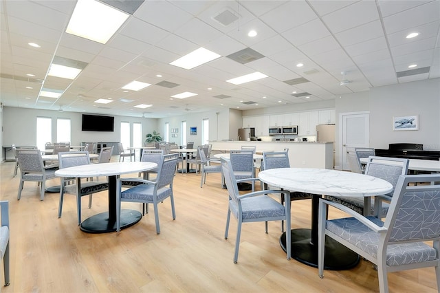 dining space with a paneled ceiling and light hardwood / wood-style floors