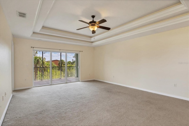 carpeted empty room featuring crown molding, a tray ceiling, and ceiling fan