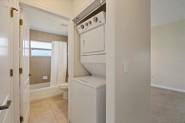 washroom featuring light carpet and stacked washing maching and dryer