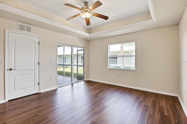 unfurnished room with a tray ceiling, ceiling fan, and dark hardwood / wood-style floors