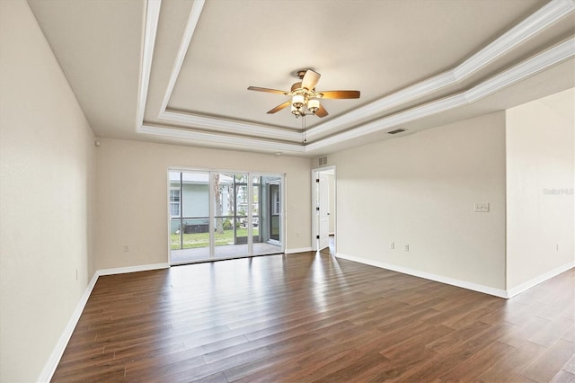 unfurnished room with a tray ceiling, ornamental molding, ceiling fan, and dark hardwood / wood-style floors