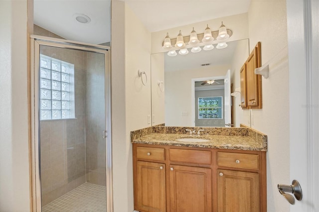 bathroom featuring walk in shower, vanity, and ceiling fan