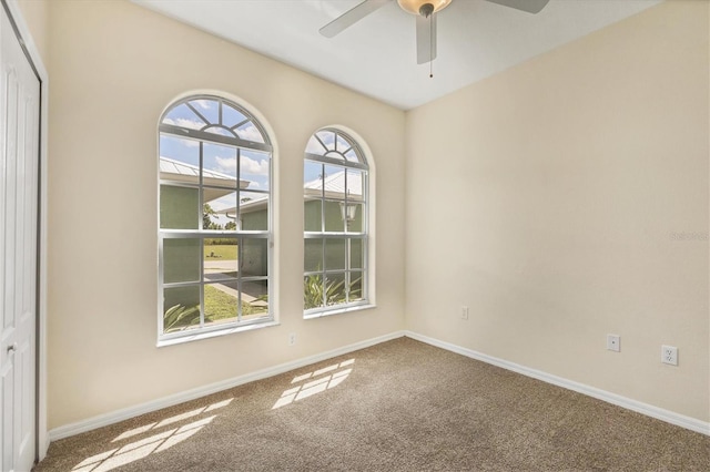 carpeted empty room featuring ceiling fan