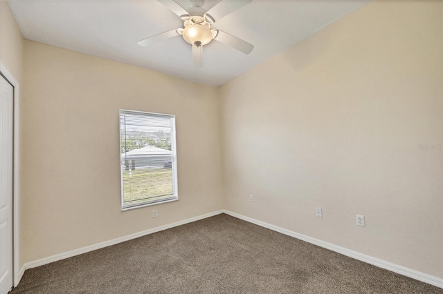 carpeted spare room featuring ceiling fan