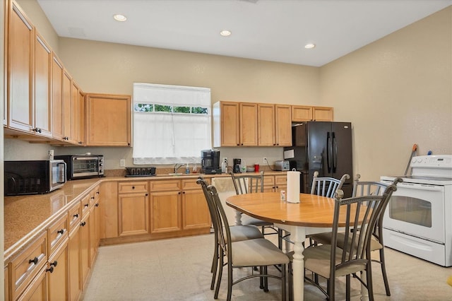 kitchen with electric stove, black refrigerator, sink, and light tile floors