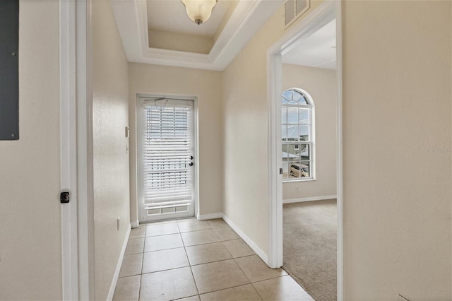 interior space featuring a raised ceiling and light tile floors