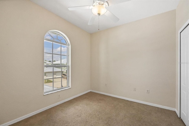 empty room with a healthy amount of sunlight, carpet flooring, and ceiling fan