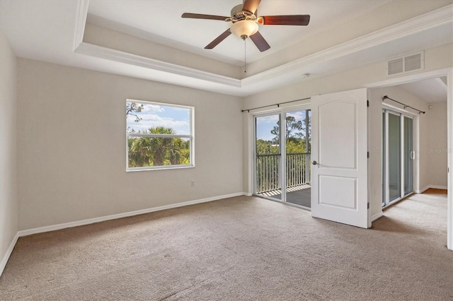 carpeted spare room featuring ceiling fan and a tray ceiling