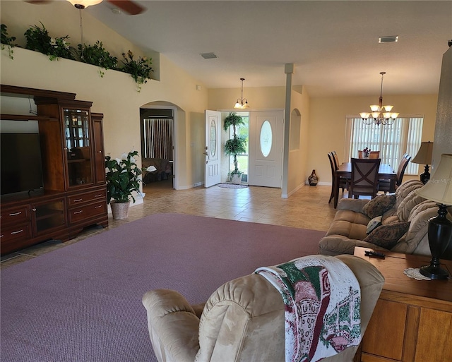 tiled living room with vaulted ceiling and ceiling fan with notable chandelier