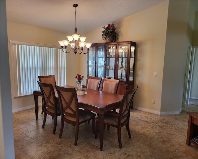 dining room with a chandelier, light tile flooring, and vaulted ceiling