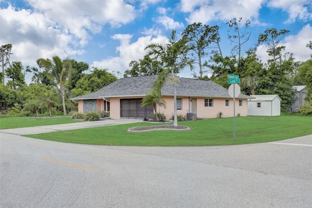 ranch-style home featuring a garage, central AC, and a front lawn