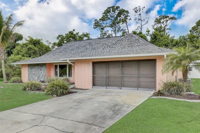 ranch-style house featuring a garage and a front yard