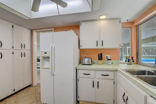 kitchen featuring ceiling fan, white cabinets, light tile patterned floors, and white fridge with ice dispenser