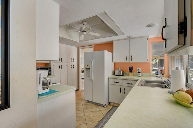 kitchen with white cabinetry, ceiling fan, white fridge with ice dispenser, sink, and light tile patterned floors