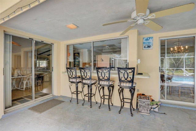 interior space featuring ceiling fan with notable chandelier