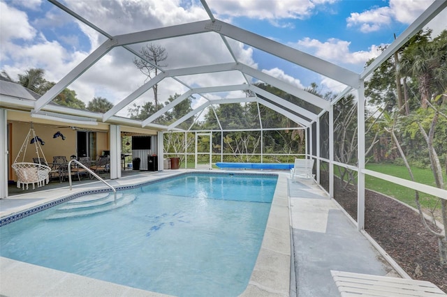 view of swimming pool with a patio and a lanai