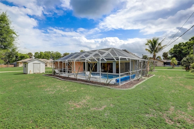 rear view of house with a shed, a patio area, a lawn, and glass enclosure