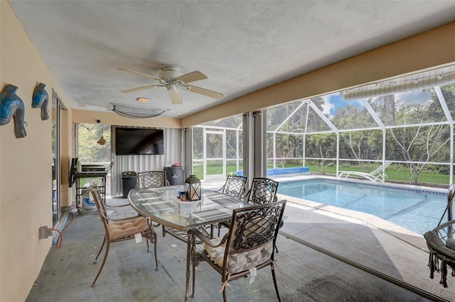 view of swimming pool featuring a lanai, a patio area, and ceiling fan