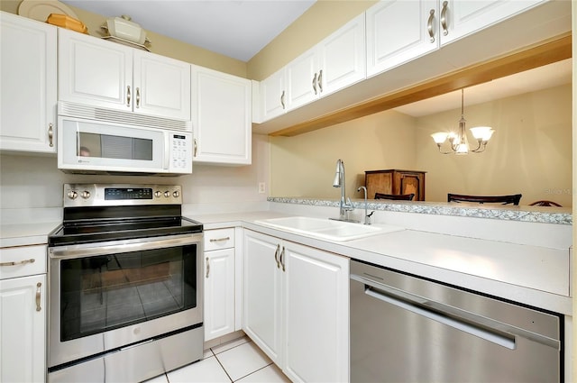 kitchen featuring a notable chandelier, sink, stainless steel appliances, white cabinets, and pendant lighting