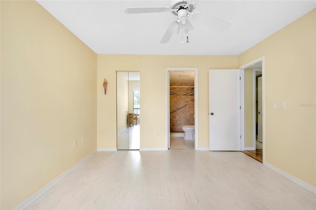 unfurnished bedroom with ceiling fan, a closet, light hardwood / wood-style flooring, ensuite bathroom, and a spacious closet