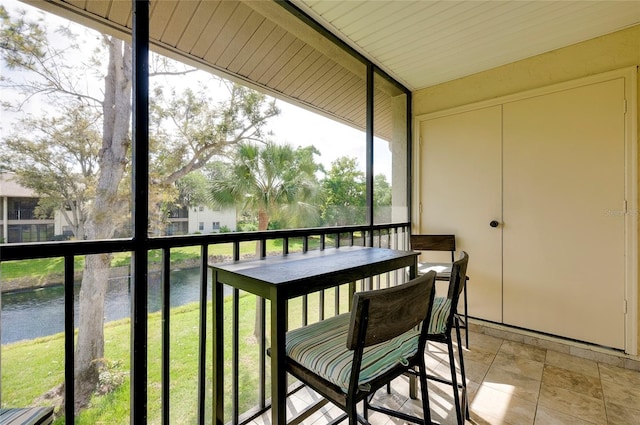 sunroom / solarium featuring a water view