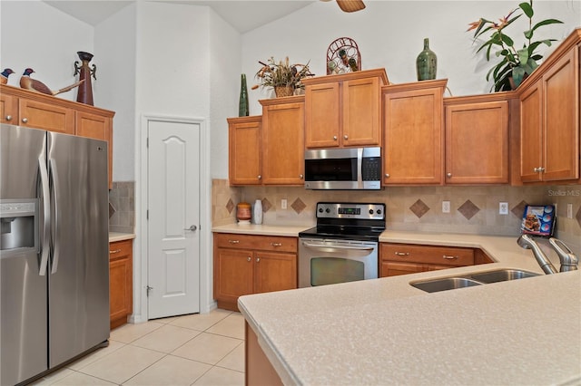 kitchen with ceiling fan, light tile floors, sink, appliances with stainless steel finishes, and backsplash