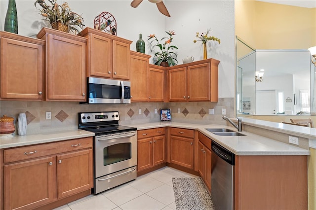 kitchen with appliances with stainless steel finishes, ceiling fan, backsplash, and sink