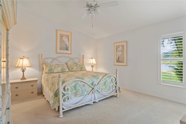 bedroom featuring light carpet, ceiling fan, and multiple windows