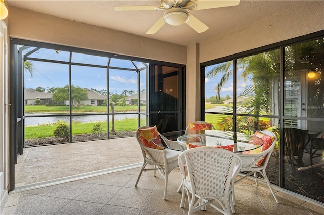 sunroom featuring a water view, a healthy amount of sunlight, and ceiling fan