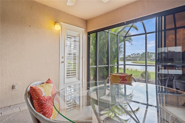 sunroom featuring a water view