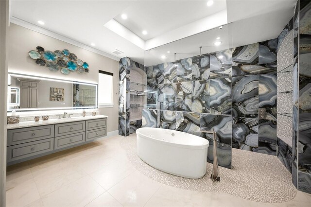 bathroom featuring vanity, a raised ceiling, a bathtub, and crown molding