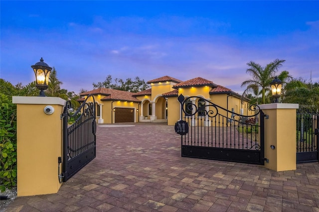 gate at dusk with a garage