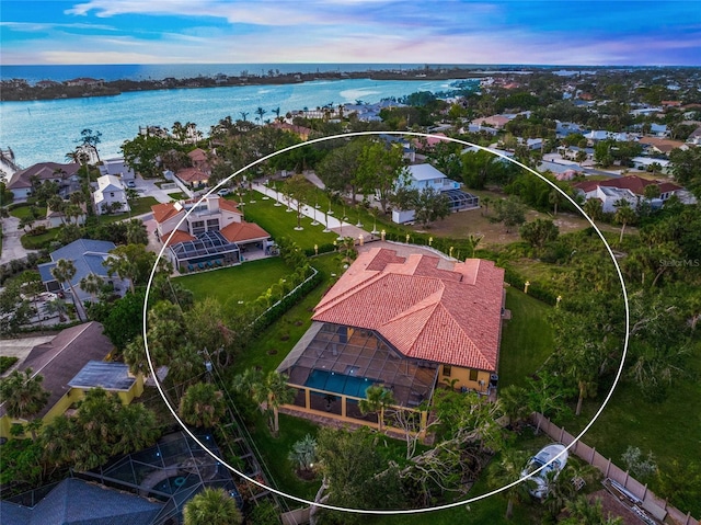 aerial view at dusk featuring a water view