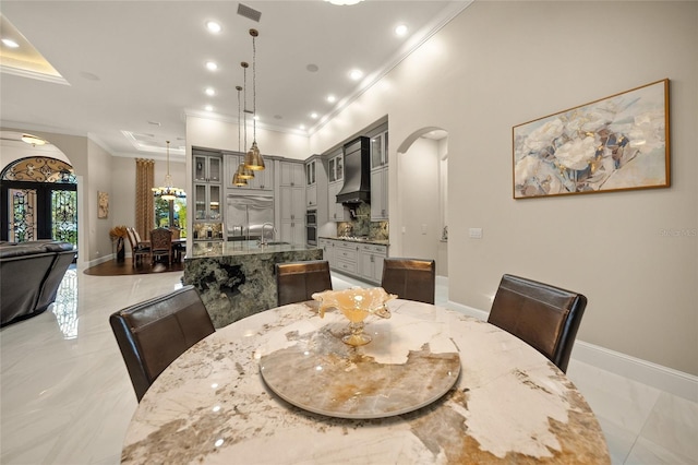 dining area with ornamental molding, sink, and french doors