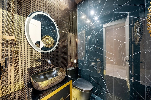 bathroom featuring vanity, toilet, and tile walls