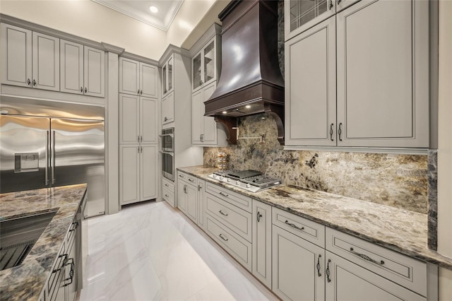 kitchen with light stone countertops, tasteful backsplash, custom range hood, stainless steel appliances, and crown molding