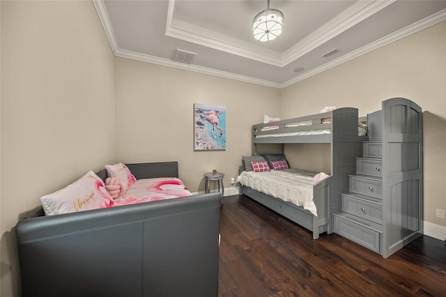 bedroom with dark hardwood / wood-style floors, ornamental molding, and a tray ceiling