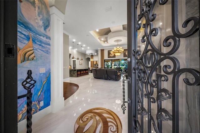 foyer with a tray ceiling and an inviting chandelier