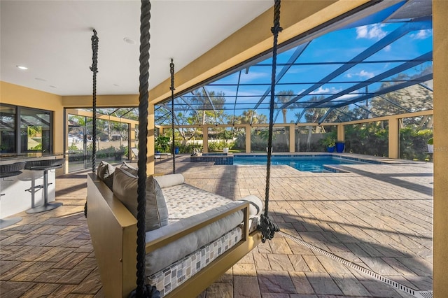 view of swimming pool with glass enclosure, a patio area, and an in ground hot tub