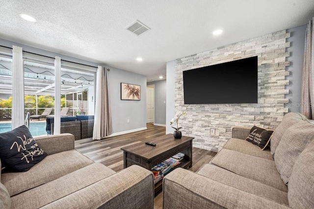 living room featuring a textured ceiling and wood-type flooring