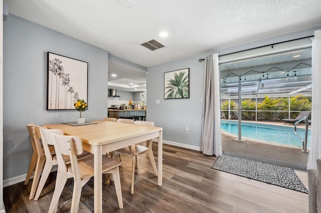 dining space with a textured ceiling and wood-type flooring