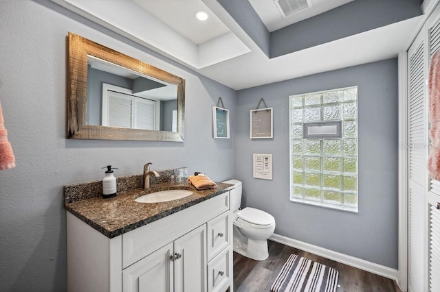 bathroom with toilet, wood-type flooring, and oversized vanity