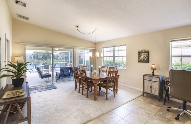 carpeted dining space featuring a textured ceiling, vaulted ceiling, and a chandelier