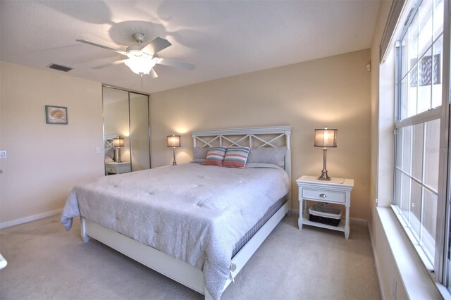 carpeted bedroom with ceiling fan and a closet