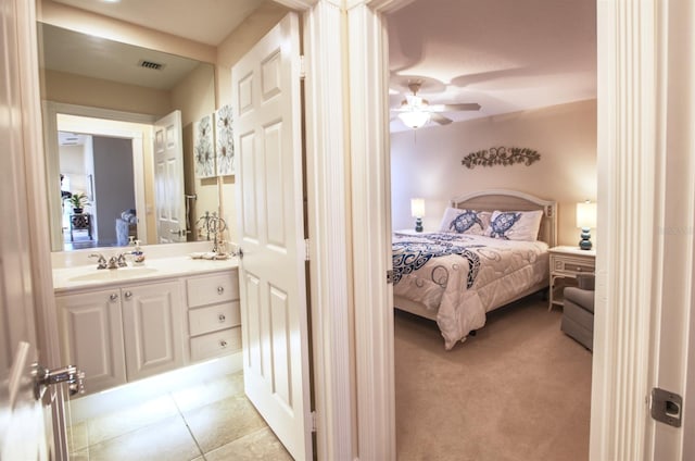 bedroom featuring ensuite bath, sink, and light colored carpet