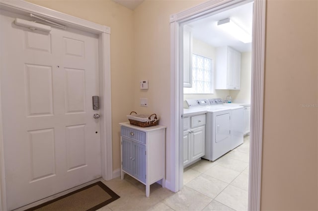 interior space featuring cabinets, light tile patterned flooring, and washer and dryer