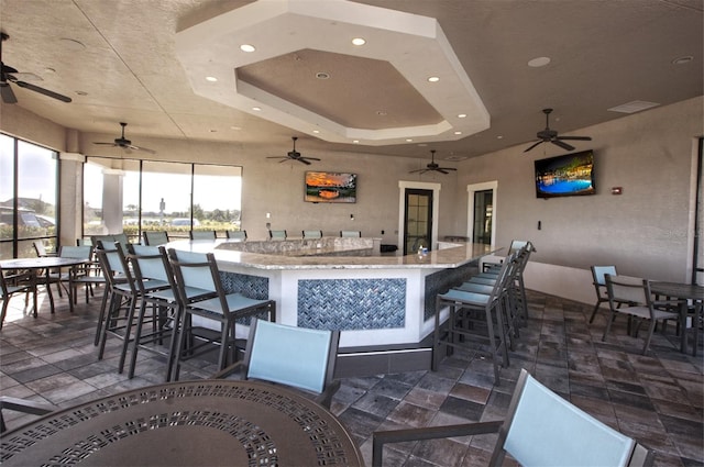 interior space with ceiling fan and exterior bar